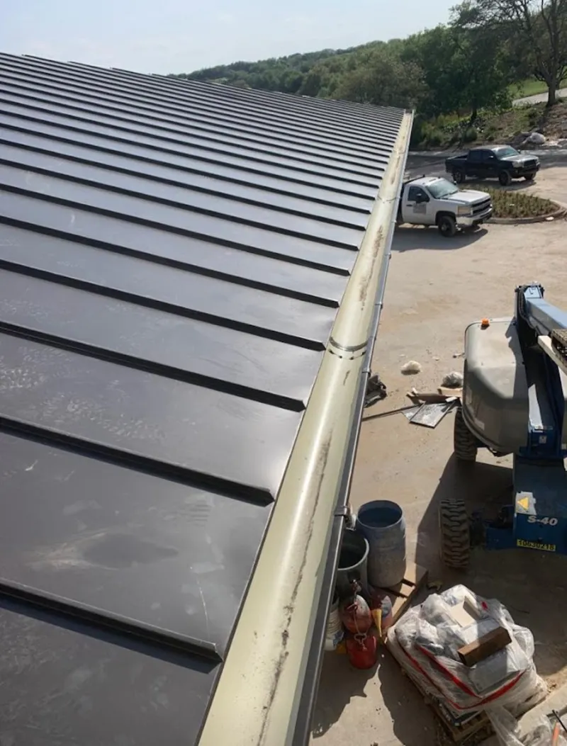 Standing seam panel and gutter detail on a metal roofing jobsite in Summerville